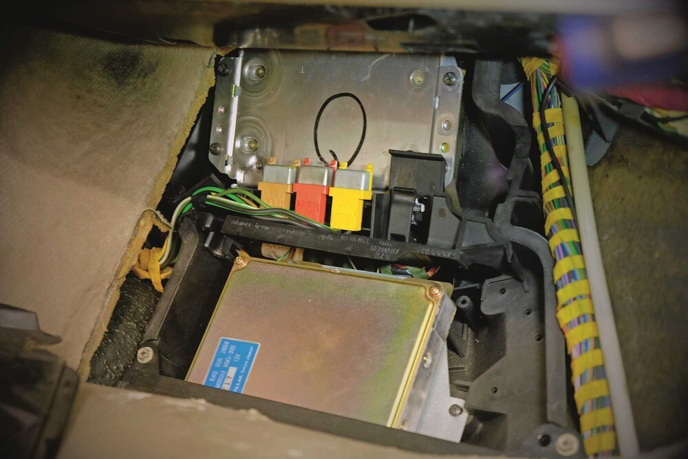 © KFZ Wirtschaft
Das Motorsteuergerät des Audi 100 versteckt sich im Beifahrer-Fußraum hinter einer Abdeckung. Das Motorsteuergerät des Audi 100 versteckt sich im Beifahrer-Fußraum hinter einer Abdeckung.