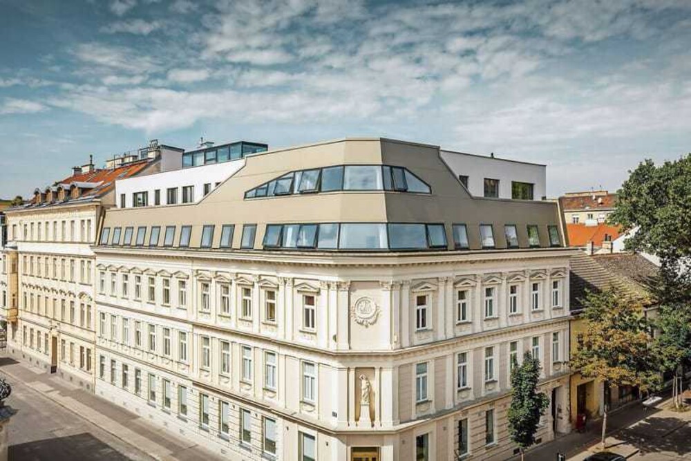 © Prefa/Croce Unkonventionell, ohne unnötigen Firlefanz wurde das Bestandsgebäude aus der Gründerzeit behutsam saniert und um einen architektonisch wertvollen Dachflächenausbau – mit viel Dachraum und wenig Dachschrägen – erweitert. Zum Highlight wurde das Sanierungsprojekt mit der straßenseitigen 80 Grad geneigten Dachfläche mit bronzefarbenen Verbundplatten von Prefa.