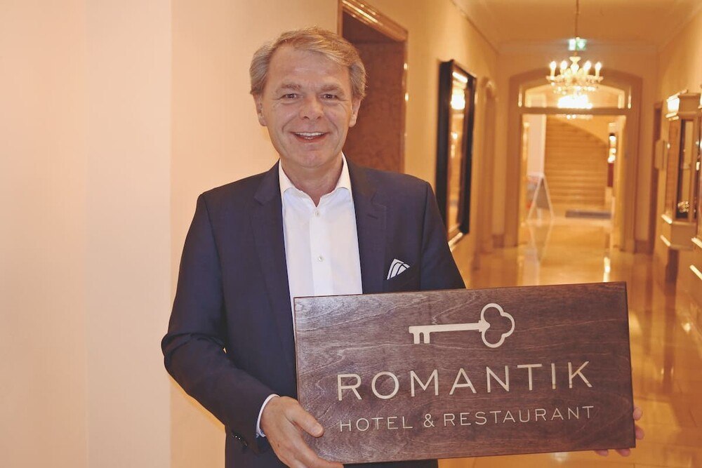 © Romantik Hotels
Romantik-Vorstand Thomas Edelkamp mit dem neuen Logo: „Das Luxussegment bei Romantik bleibt familiär geprägt“. Romantik-Vorstand Thomas Edelkamp mit dem neuen Logo: „Das Luxussegment bei Romantik bleibt familiär geprägt“.