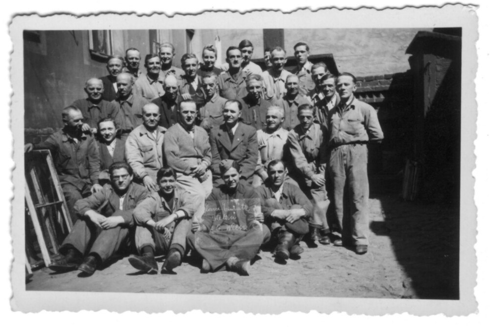 Gruppenbild des Einsatzes von 31 Wiener Glasern in Stettin. Der junge Mann vorne in der Mitte hält eine Glastafel in der Hand, die Aufschrift lautet „Glaser-Einsatz Stettin A.G. Wien“.
© Archiv Elfriede Zahlner Gruppenbild des Einsatzes von 31 Wiener Glasern in Stettin. Der junge Mann vorne in der Mitte hält eine Glastafel in der Hand, die Aufschrift lautet „Glaser-Einsatz Stettin A.G. Wien“.