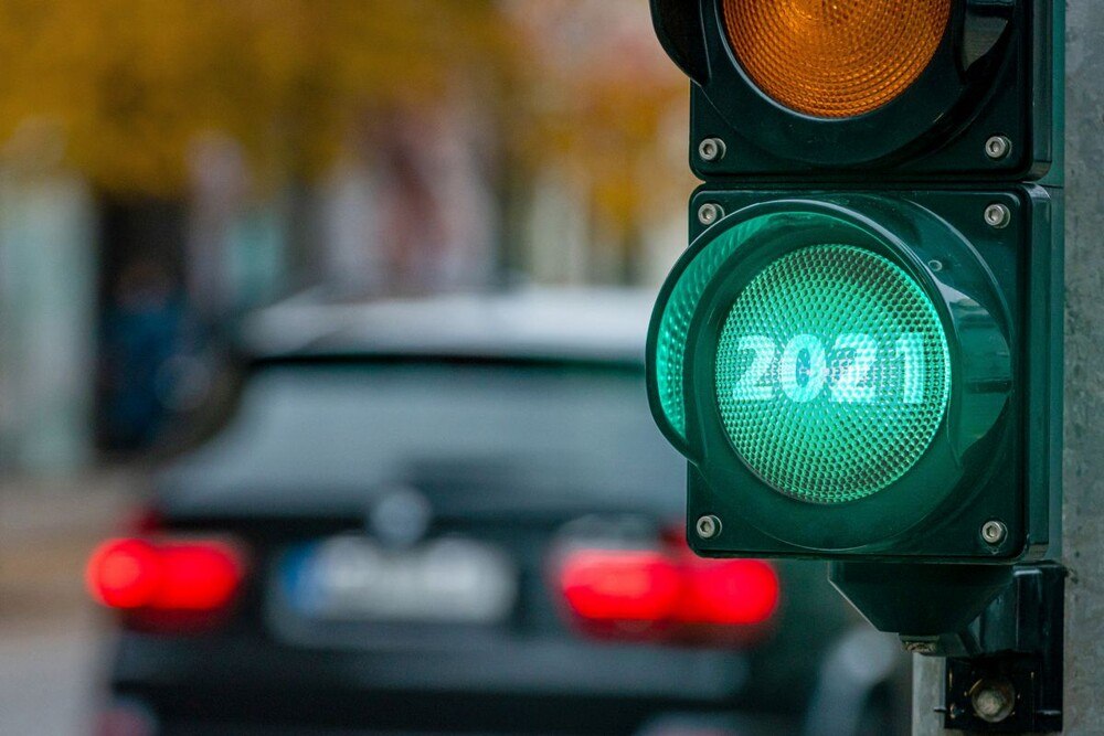 Grüne Ampel, die 2021 zeigt, und ein Auto im Hintergrund