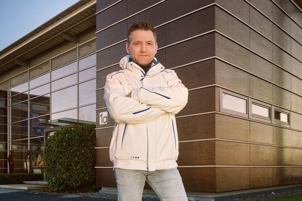 © Akzo Nobel Deco GmbH
Die Sikkens Akademie macht den Baustoff Holz in einem neuen Veranstaltungsformat live erlebbar., basic_html Mann steht vor einem dunkelbraunen Holzhaus