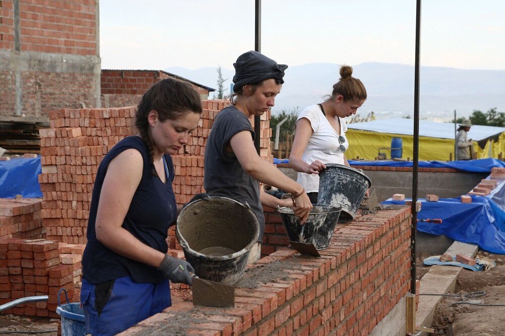 © Sto-Stiftung Drei Studentinnen arbeiten an einer Ziegelmauer