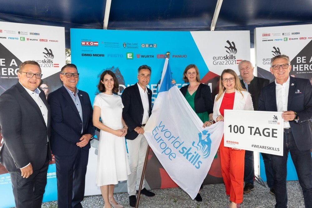 © EuroSkills 2020 GmbH/GEOPHO Startschuss für den Countdown in Graz (v. l.): Martin Graf (Vorstandsdirektor Energie Steiermark), Klaus Leutgeb (Betreiber Schwarzl Freizeitzentrum), Amelie Groß ( WKÖ-Vizepräsidentin), Siegfried Nagl (Bürgermeister der Stadt Graz), Barbara Eibinger-Miedl, (Landesrätin für Wirtschaft, Tourismus, Regionen, Wissenschaft und Forschung), Margarete Schramböck (Ministerin für Wirtschaftsstandort und Digitalisierung), Stefan Praschl, (Vizepräsident World Skills Europe) und Josef Herk (WKO Steiermark-Präsident sowie EuroSkills 2021-Initiator) Bei Startschuss für den Countdown in Graz: 8 Personen mit EuroSkills-Fahne und "100 Tage Countdown"-Schild