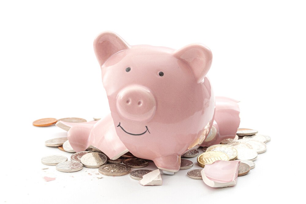 © Getty Images/Moussa81 Der KSV1870 rechnet nicht mit einer Insolvenz-Welle, sondern ab Herbst 2021 mit einem leichten Ansteigen der Insolvenzen. Zerschlagenes rosa Sparschwein, mit Münzen rundherum.