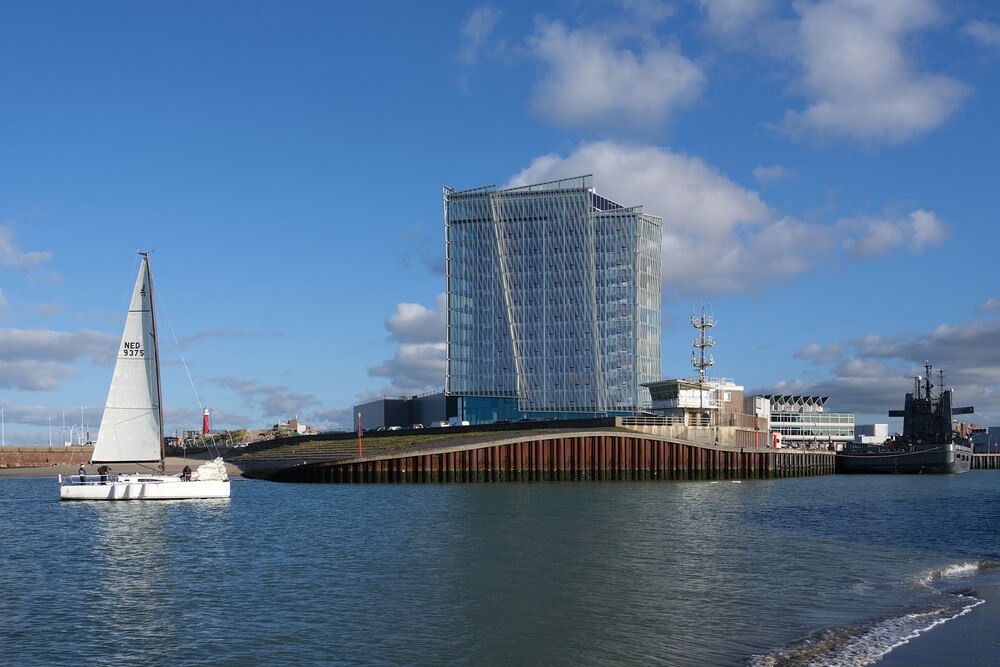 Solitär am Meer: Das architektonische Design des 4-Sterne Inntel Hotel Den Haag Marina Beach greift das nautische Thema auf. Der dreieckige Hotelbau steht an der Spitze des Piers und sieht von jedem Aussichtspunkt anders aus, keine Fassadenseite ist gleich. 