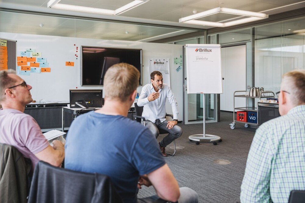 © Brillux Die Brillux Akademie bietet ein vielfältiges Weiterbildungsprogramm für Malerinnen und Maler. Vortragender und drei Teilnehmer bei einem Brillux-Seminar.