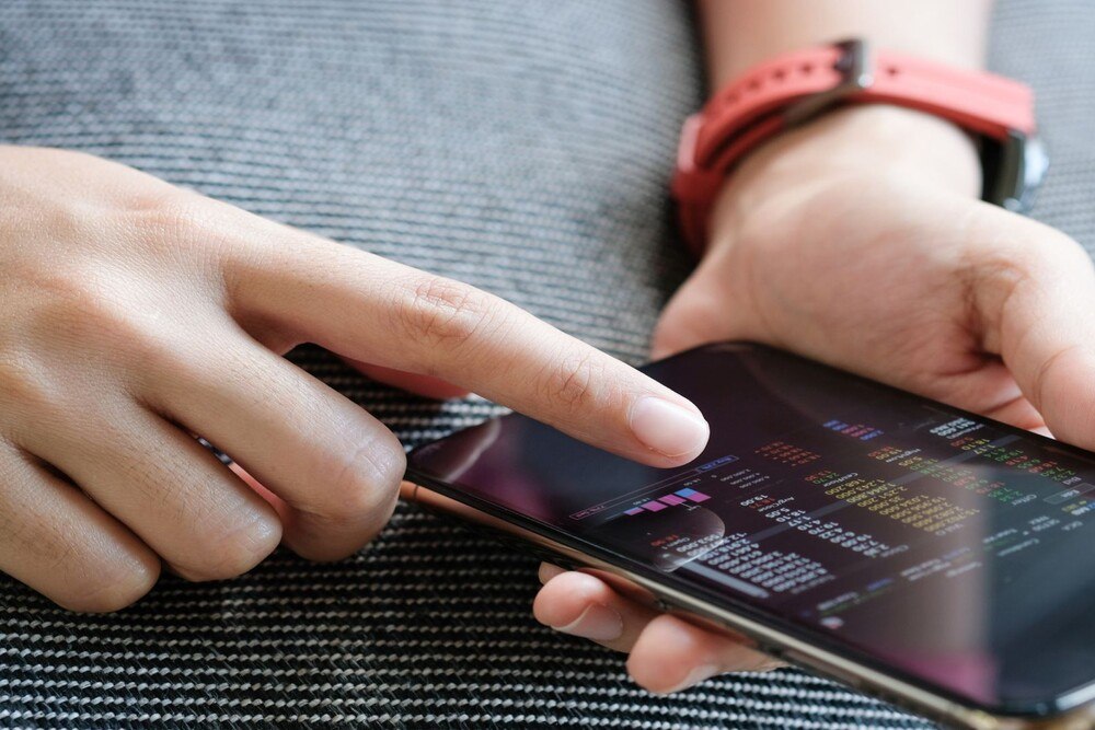 © Getty Images / Ake Ngiamsanguan
Eine Frau überprüft Börsekurse auf ihrem Handy.
, restricted_html Eine Frau überprüft Börsekurse auf ihrem Handy.