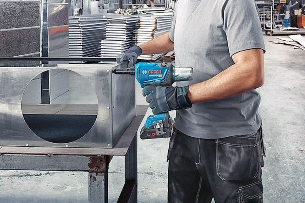 © Bosch
Der GRG 18V-16 C Professional deckt mit Blindniet-Durchmessern von drei bis 6,4 Millimetern das größte Anwendungsspektrum seiner Klasse ab. Es können sowohl dünne als auch dicke Metallbleche vernietet werden, zum Beispiel im Lüftungs-, Fassaden- und Fahrzeugbau. Dabei ist weder ein Gerätewechsel notwendig noch ein Austausch von Komponenten. Lediglich das passende Mundstück muss ausgewählt werden. Alle Mundstücke, die gerade nicht verwendet werden, sind wie der Spannschlüssel zum Wechseln sicher am Gerät verstaut und stets griffbereit. Die Nietdorne werden nach jedem Nietvorgang im Auffangbehälter gesammelt, damit sie nicht herunterfallen.
Akku-Nietpistole von Bosch