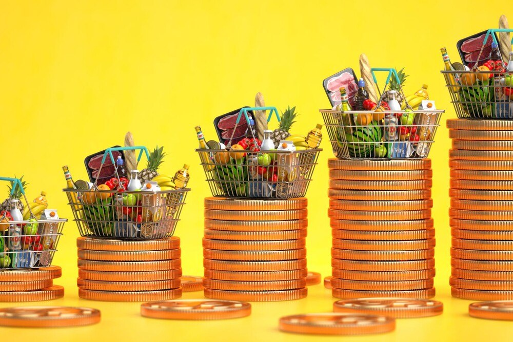 © iStock / Getty Images Plus / Bet_Noire Einkaufskorb mit Lebensmitteln mit Münzstapeln