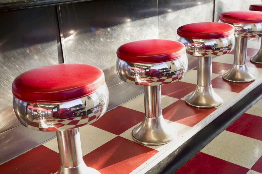 Chromsitzen mit roter Polsterung in einem typischen amerikanischen Diner.
© iStock / Getty Images Plus / ricardoreitmeyer Chromsitzen mit roter Polsterung in einem typischen amerikanischen Diner.