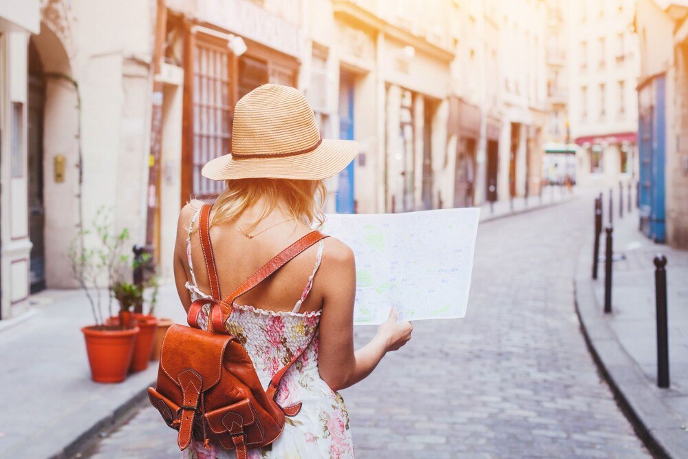 © iStock / Getty Images Plus / anyaberkut Eine Urlauberin blickt auf eine Stadtkarte.