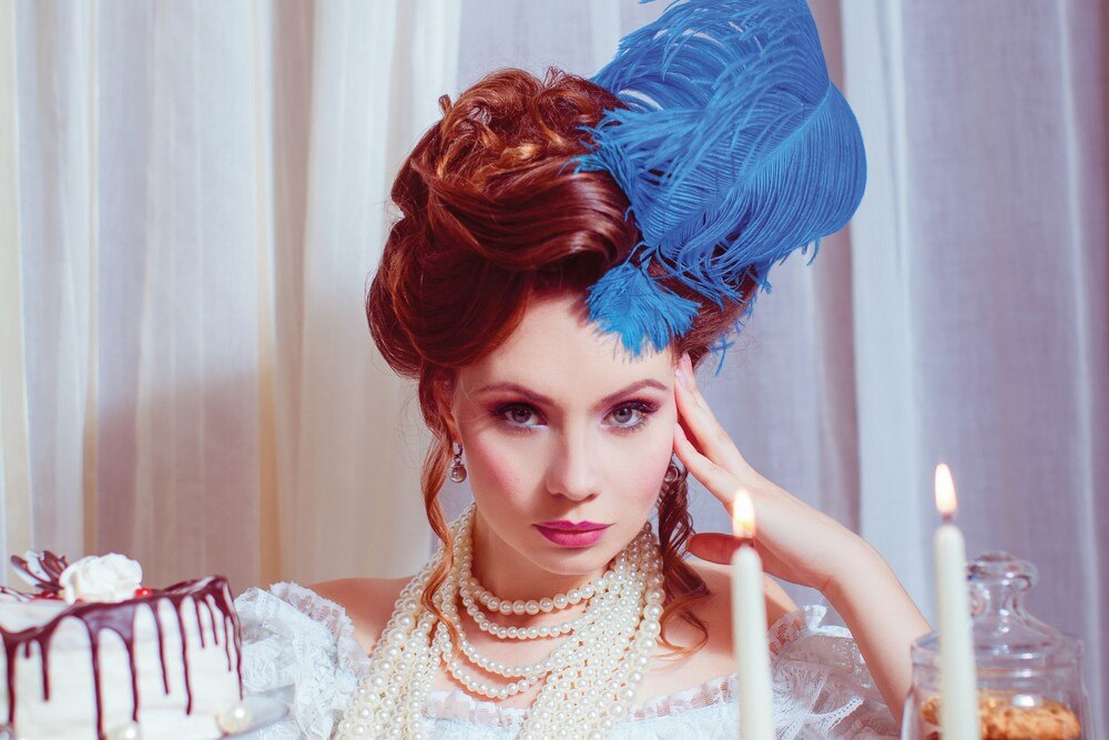 © uzhursky via Getty Images Eine Dame mit Federschmuck in historischem Kostüm