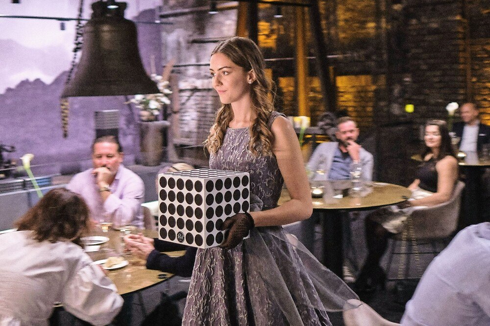 © POET & Senns Audio Dinner Eine Servicekraft trägt einen Lautsprecher zu einem Tisch