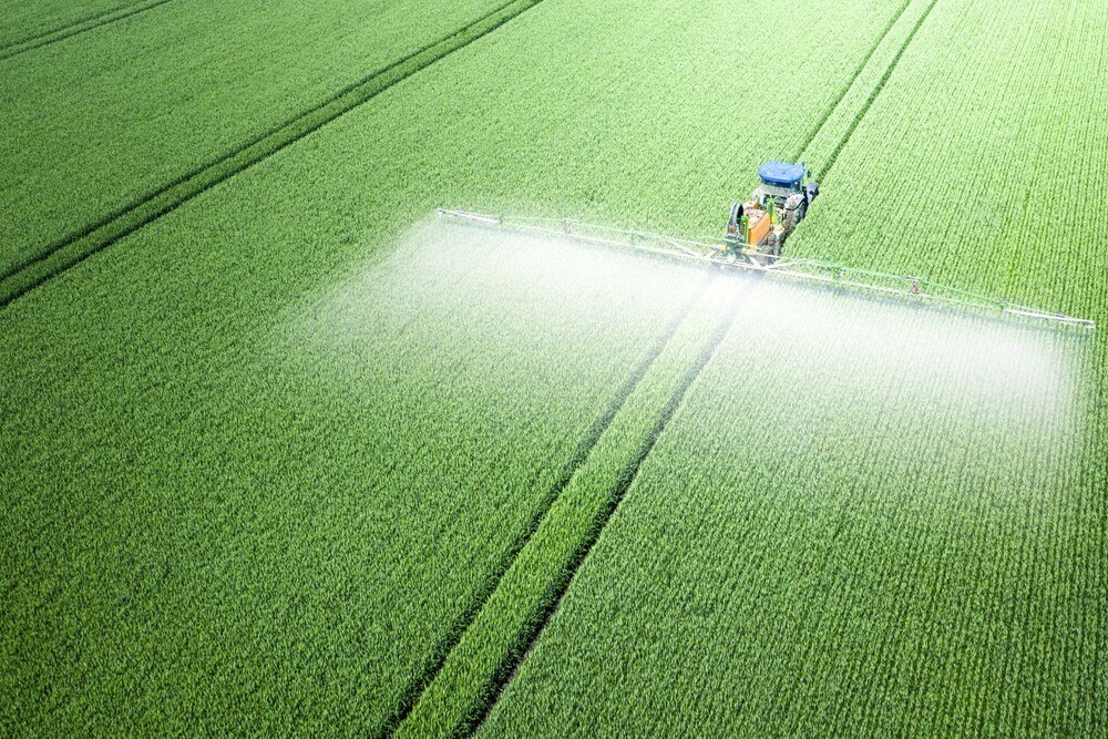 © iStock / Getty Images Plus / MaYcaL Luftaufnahme einer landwirtschaftlichen Fläche mit Sprühwagen