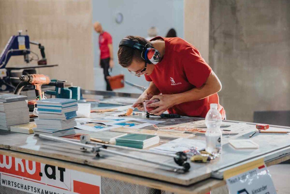 © WKÖ/SkillsAustria
Durch Können, Nervenstärke und der mentalen Unterstützung von 40 mitgereisten Fans aus der Heimat krönte sich Alexander Gfellner in Bozen zum Fliesenleger-Weltmeister.
Durch Können, Nervenstärke und der mentalen Unterstützung von 40 mitgereisten Fans aus der Heimat krönte sich Alexander Gfellner in Bozen zum Fliesenleger-Weltmeister.