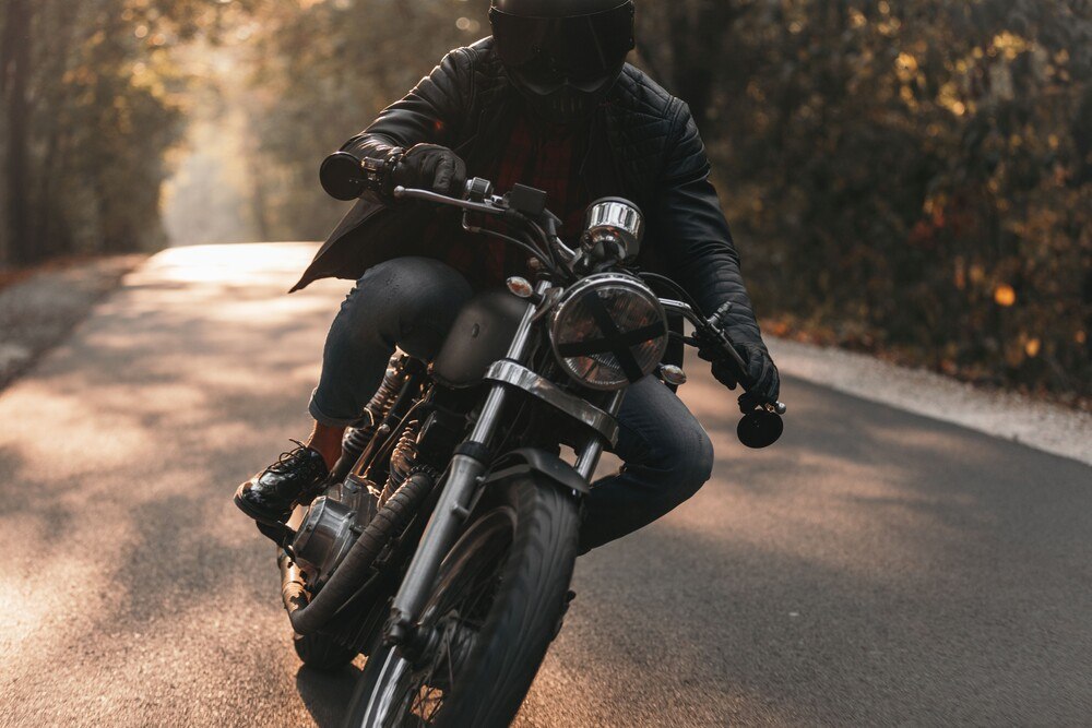 © istock-1186348217 Dunkel gekleideter Mann auf schwarzem Motorrad