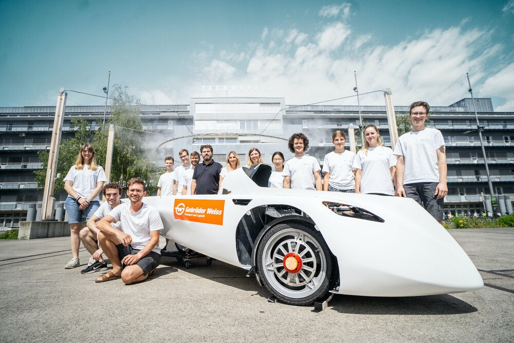 © Gebrüder Weiss / Roman Hartl
Das Solarauto mit dem Team der ETH Zürich und Frank Haas, Leiter Kommunikation (7. von links) Katharina Zimmerling, Niederlassungsleiterin Air & Sea Zürich, und Vanessa Hafner, Team Lead Digital Communications (rechts daneben, alle Gebrüder Weiss).
Das Solarauto mit dem Team der ETH Zürich und Frank Haas, Leiter Kommunikation (7. von links) Katharina Zimmerling, Niederlassungsleiterin Air & Sea Zürich, und Vanessa Hafner, Team Lead Digital Communications (rechts daneben, alle Gebrüder Weiss).