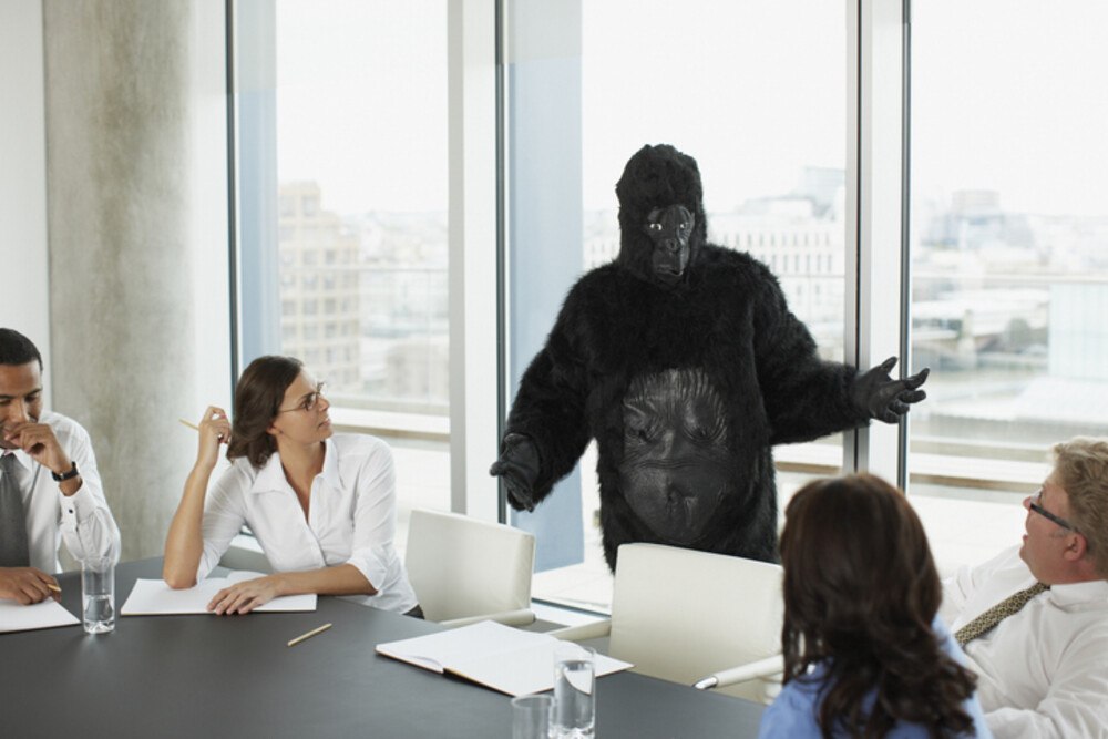 © Paul Bradbury iStock Getty Images Plus Eine Person in einem Gorillakostüm in einem Meeting