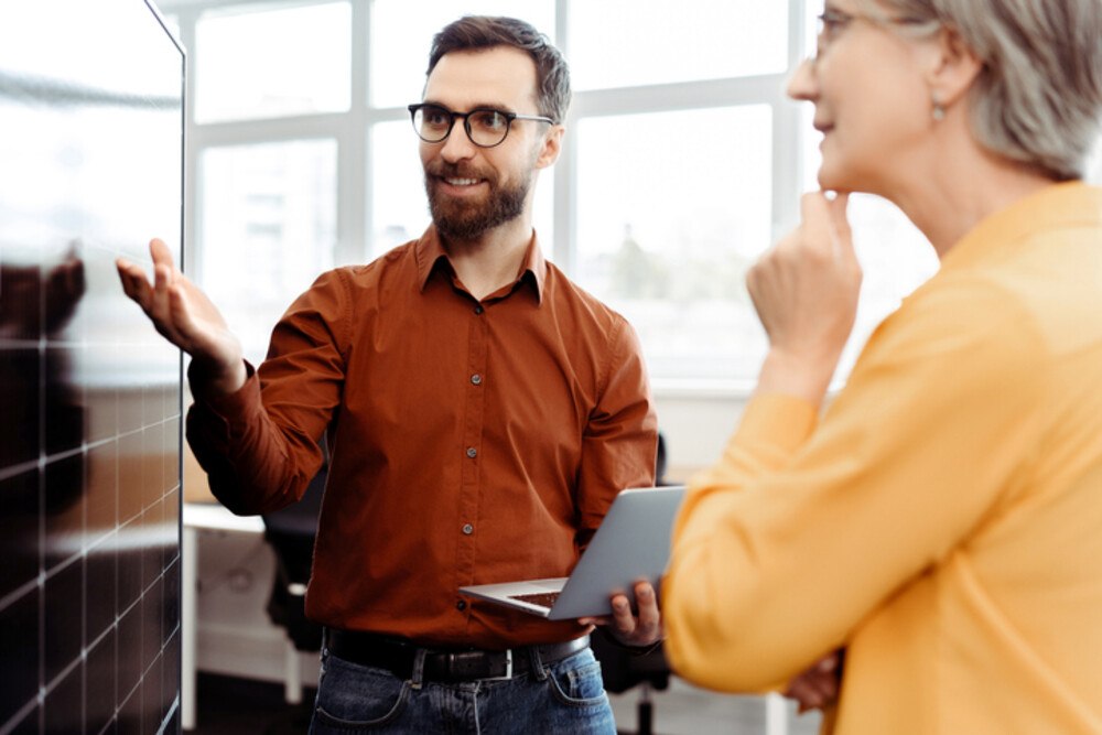 Beratungsgespräch vor Solarpanel