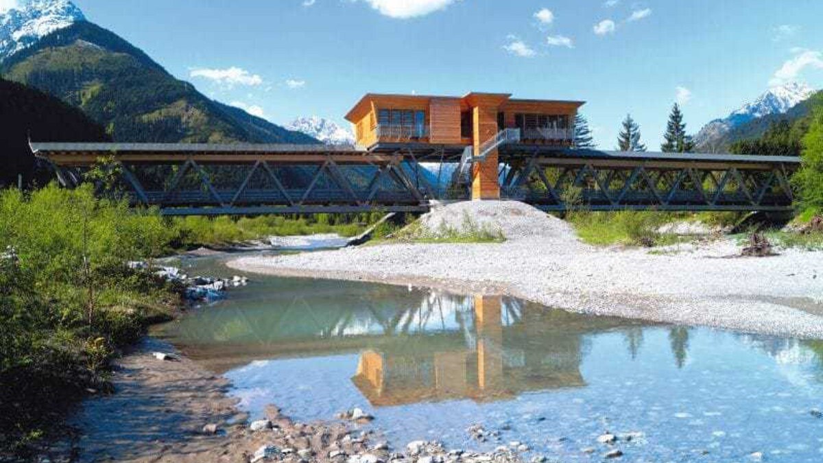 Die ursprüngliche frei­tragende Brücken­konstruktion mit einer Länge von 42 Metern musste nach dem Hochwasser und der Verbreiterung des Flussbetts im Jahr 2006 um 35 Meter verlängert werden.