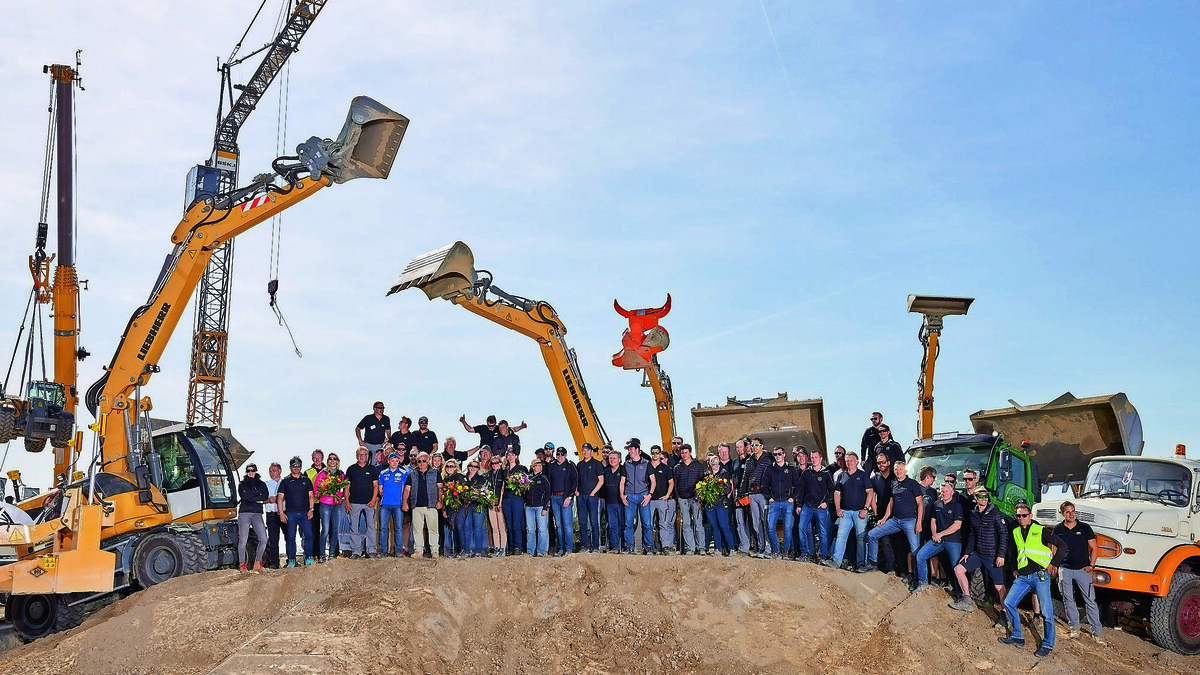 Gäste, auf einem aufgeschütteten Hügel, vor Baumaschinen versammelt