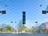 Zehn unterschiedlich dimensionierte Aluminium-Dreiecke sind so angeordnet, dass sich die Verläufe der Schindeln als Wirbel auf der Fassade abbilden.