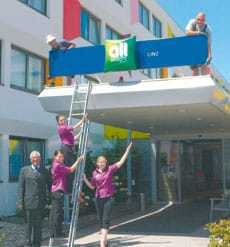 Hoteldirektor Johann Kaiser montiert mit seinen Mitarbeitern das all-seasons-Logo in Linz