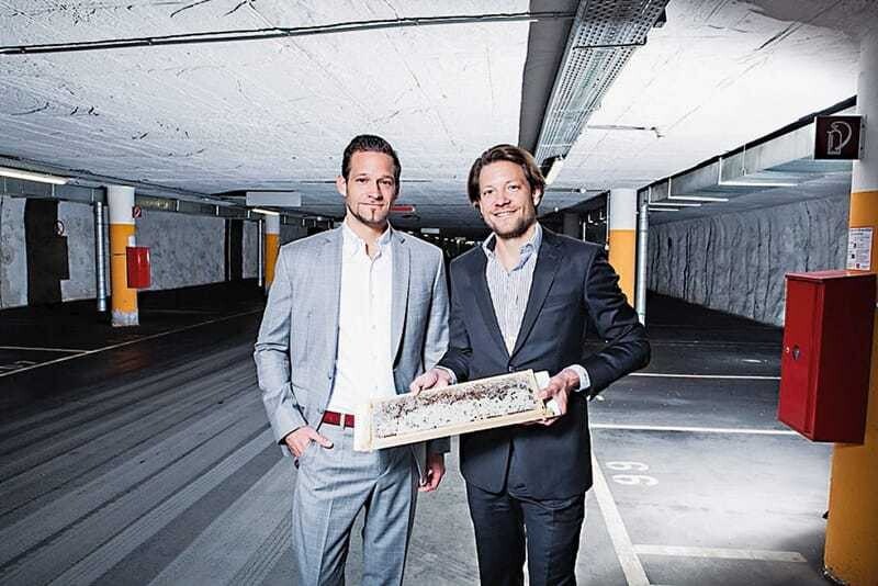 © Mühlberger/Kronberger Markus (links) und Michael Ploberger in der Tiefgarage zu ihrem Hotel. In der Hand halten sie eine Honigwabe vom Bio-Frühstücksbüffet.