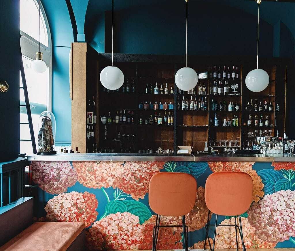 Die Bartheke im floralen Design mit dem dahinter liegendem Apothekerregal.
