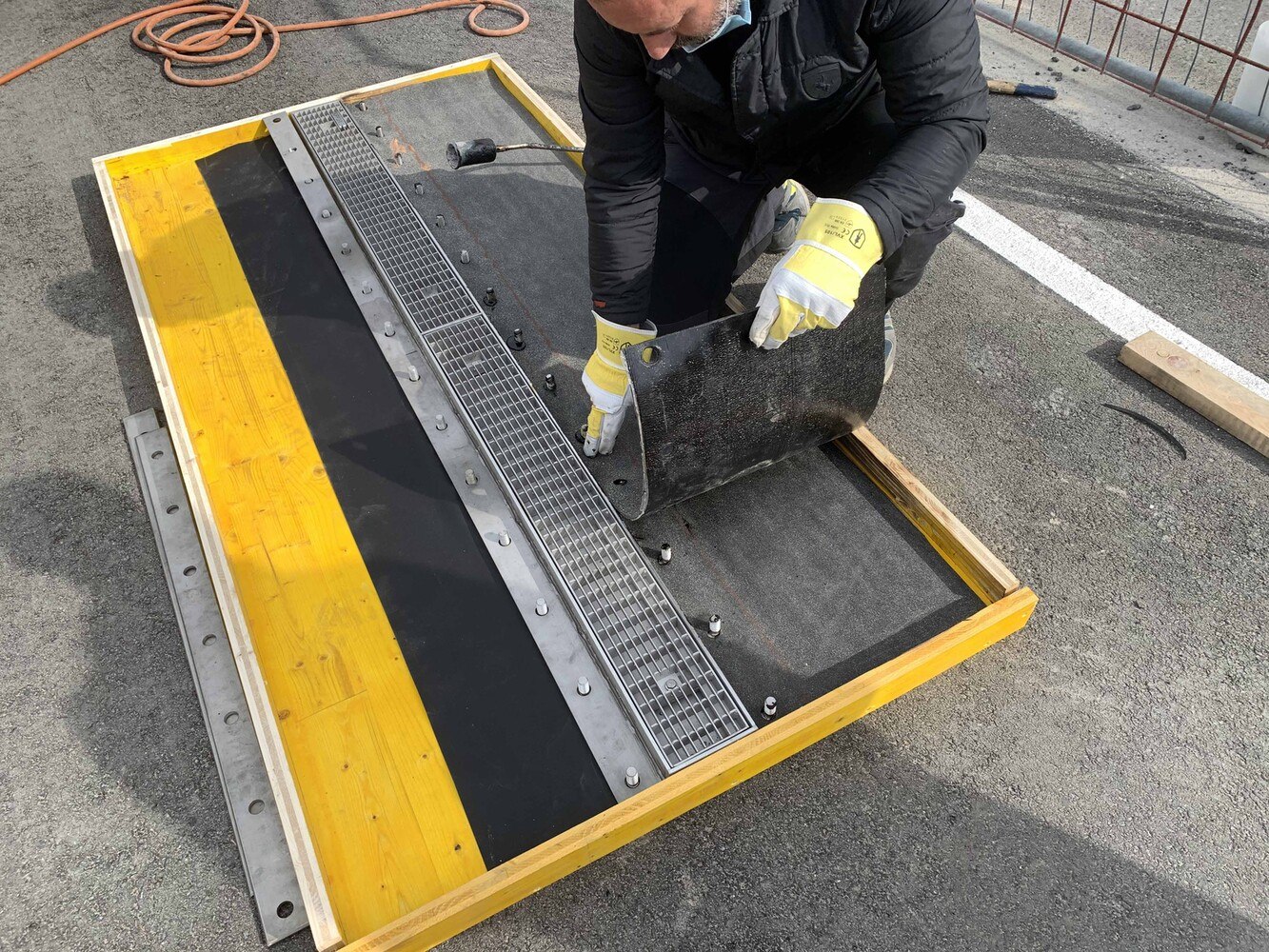 Praxisversuch des Forschungsprojekts: Zielsetzung war, auf einem Metallflansch zwei Bitumenlagen aufzuflämmen und am anderen Flansch eine Lage Butyl-Kunststoffbahn aufzukleben. Mit dem Losflansch wurden beide Abdichtungsstoffe geklemmt.
