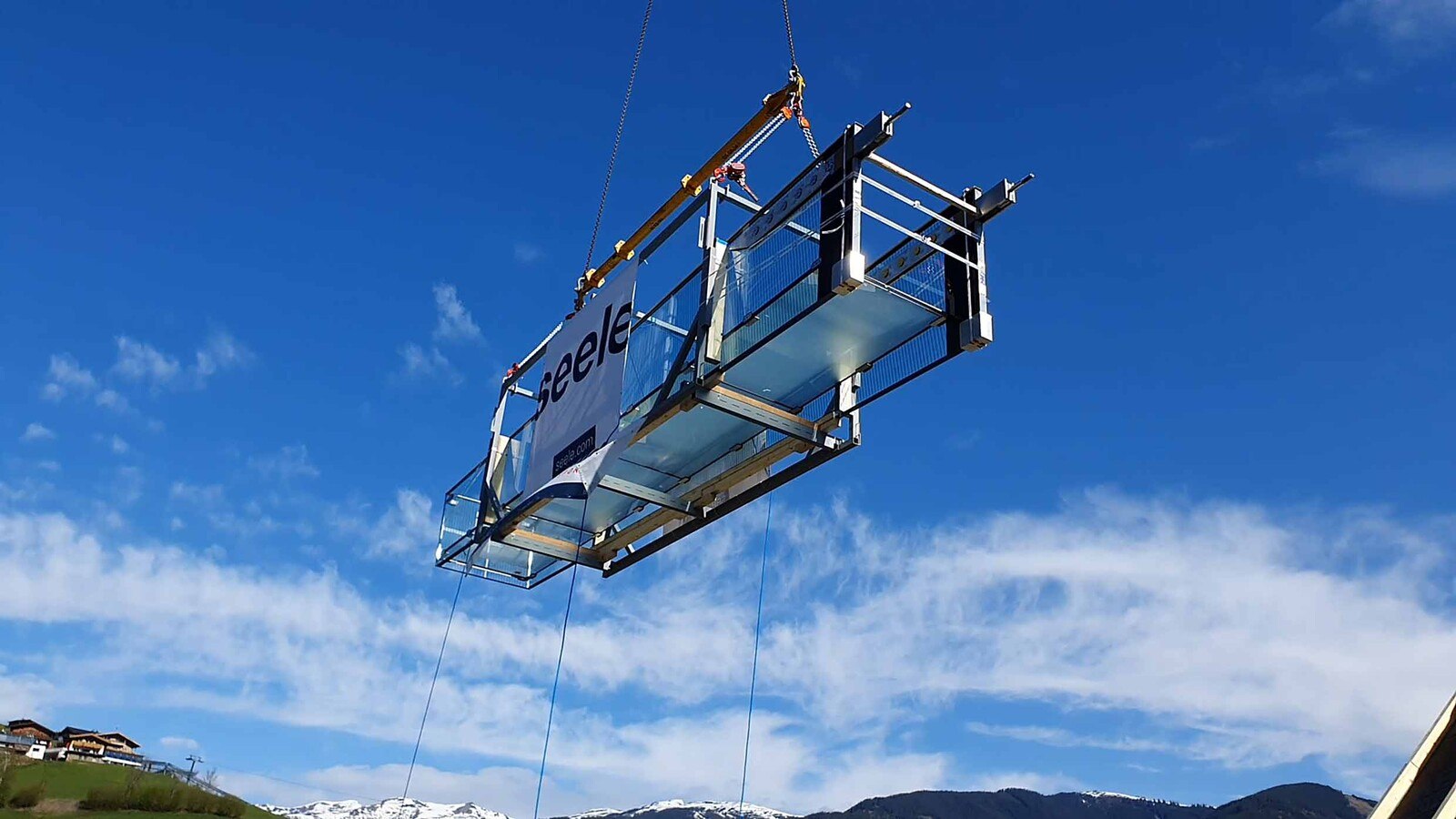 Der 45 lange Ausleger eines Teleskopkrans hob den vormontierten Glassteg über das Bründls Sports-Gebäude zur Einbaustelle im vierten Obergeschoß. 