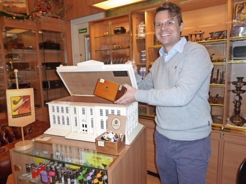 Tristan-Boris Lukele hat offensichtlich Freude an seiner Trafik. Da dürfen dann auch einmal verspielte Accessoires wie der Humidor in der Optik des Weißen Hauses sein. U