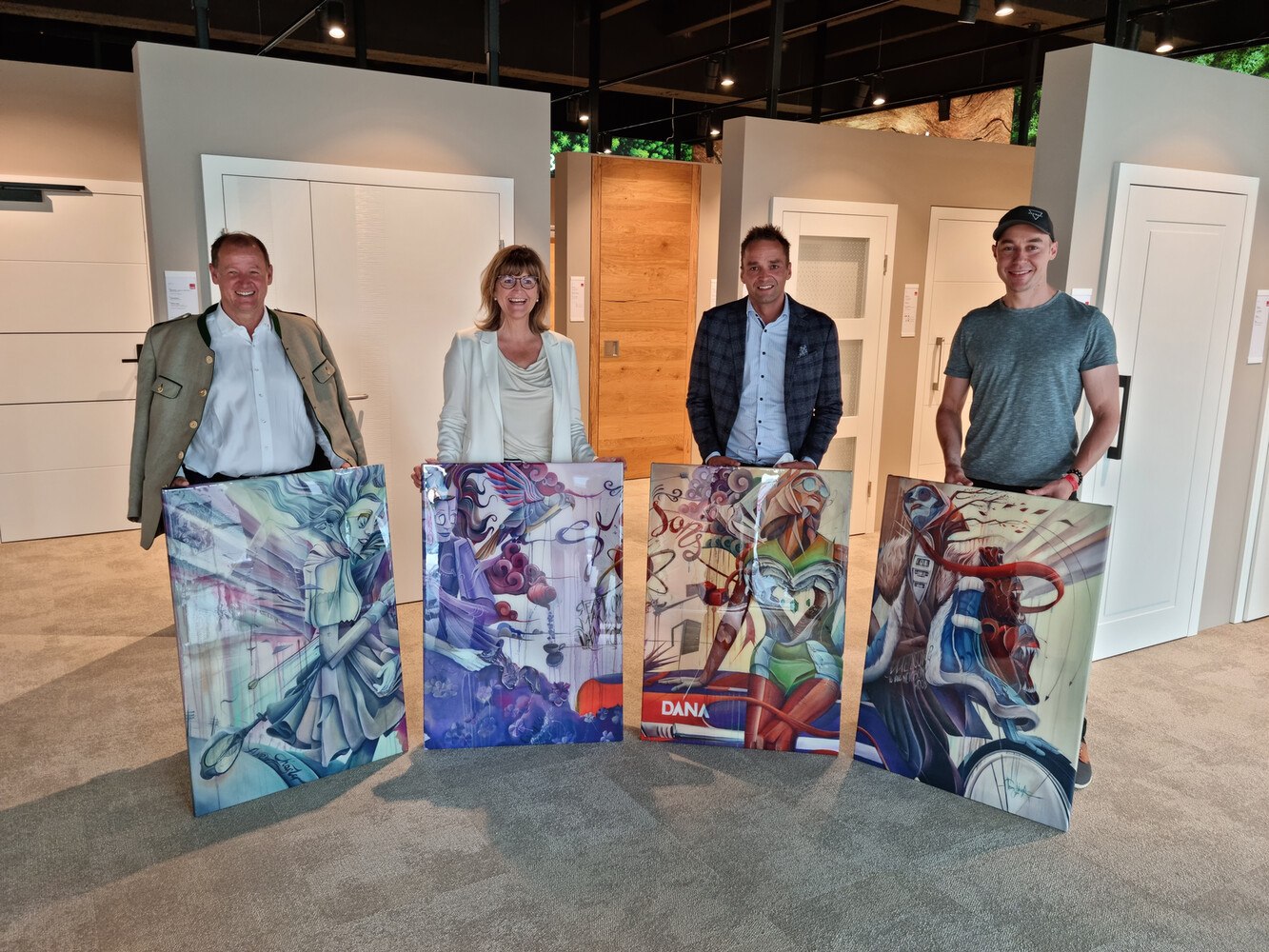 Zur Eröffnung des Schauraums überreichte Vermieter Christof Schell dem DANA Team vier speziell angefertigte Bilder des Künstlers Tom Lohner: (v.l.) Christof Schell (Vermieter), Gertraud Scheuchel (DANA JELD-WEN Head of Brand und Marketing), Daniel Egger (DANA JELD-WEN Geschäftsführung) und Künstler Tom Lohner  
