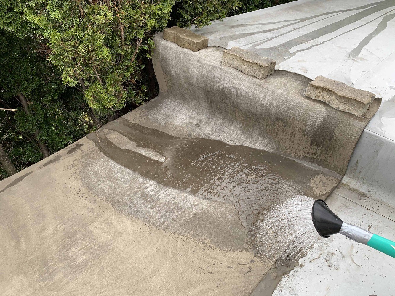 Bei den Modellversuchen befand sich zwischen der Gewebebetonmatte und der Kunststoffabdichtungsbahn keine zusätzliche Schutz- oder Trennschicht. Nach dem Verlegen wurde die Matte mit ca. 20 l Wasser begossen und beschwert.