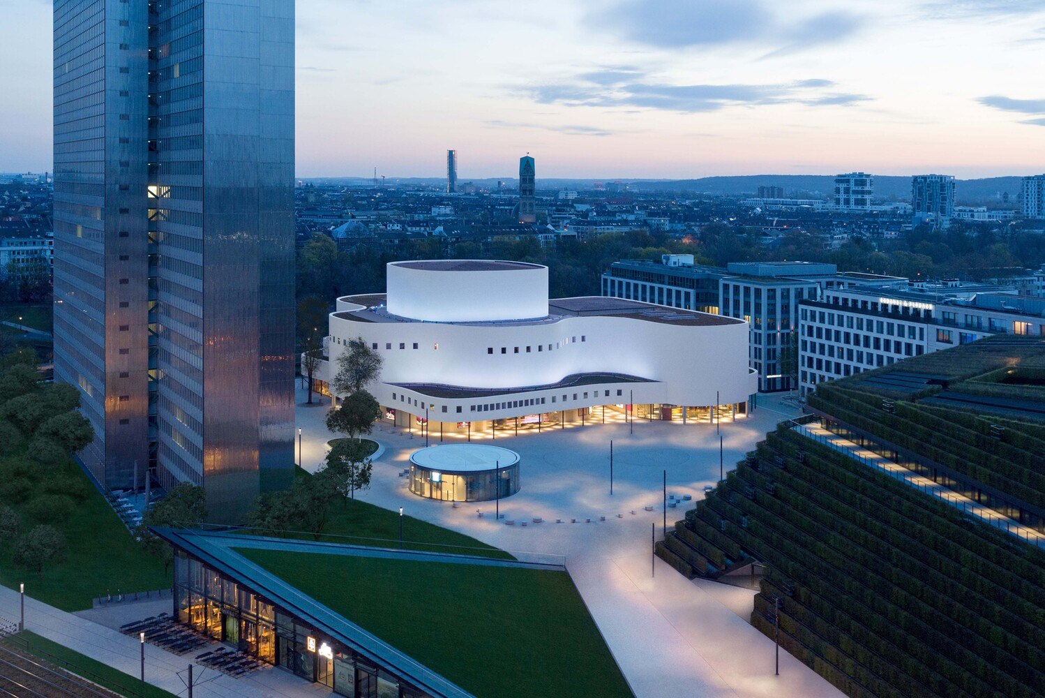 Das denkmalgeschützte Schauspielhaus Düsseldorf ist aus drei zusammengelegten Schichten konzipiert, die als weiche Formen horizontal gestapelt sind. Die Fassadenbekleidung aus gewelltem und farbbeschichtetem Aluminiumblech führt ohne störende Zäsur über den Dachrand und entspricht im Erscheinungsbild der Ursprungsfassade.