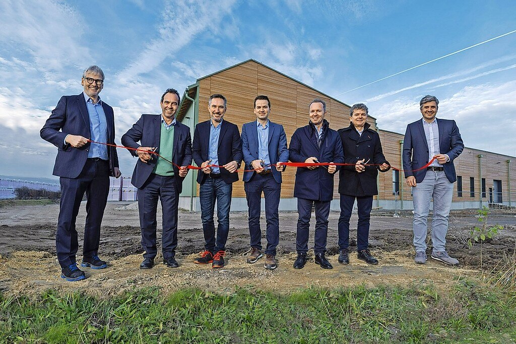 Sieben Männer vor Produktionshalle