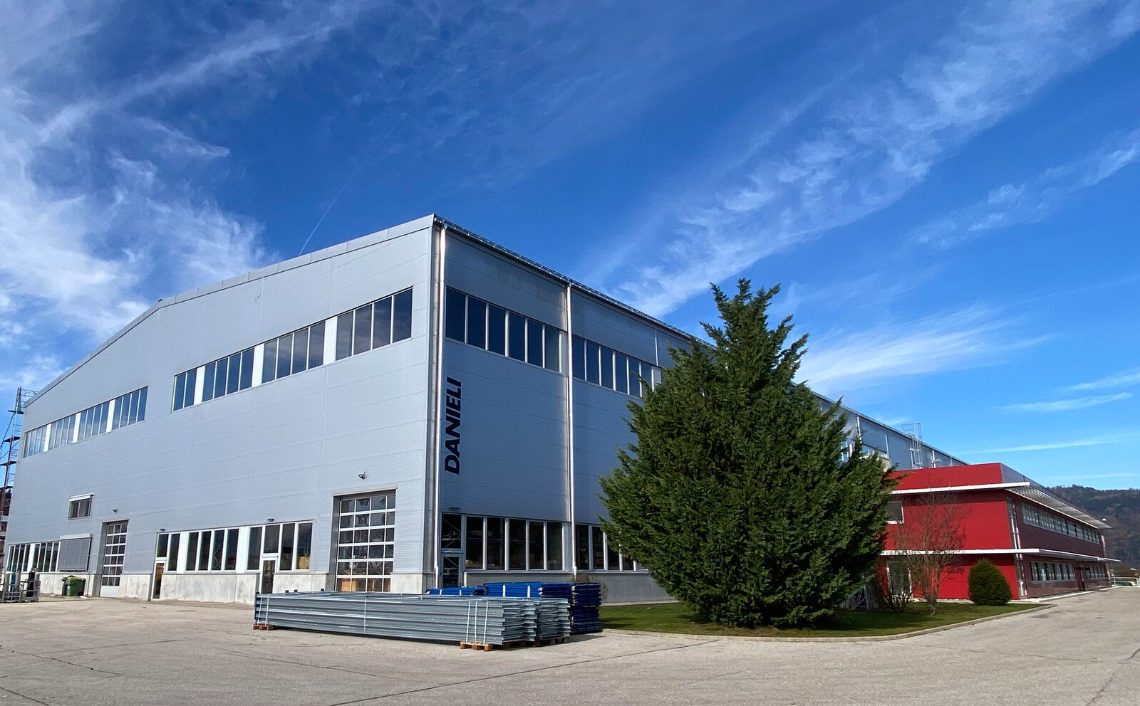 Moderne Produktionshalle mit neuem Dach: Die Danieli Engineering & Services GmbH ist Teil der Danieli Gruppe, einer der weltweit führenden Engineering- und Anlagenbauunternehmen für die Eisen- und Stahlindustrie bzw. der Aluminiumindustrie.