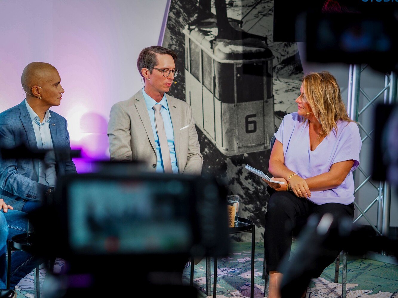 Patricio Hetfleisch (Marketingleiter Tirol Werbung, l.) und Philip Krammer (CEO Terawind) im Öko-Talk mit Moderatorin Verena Schneider.