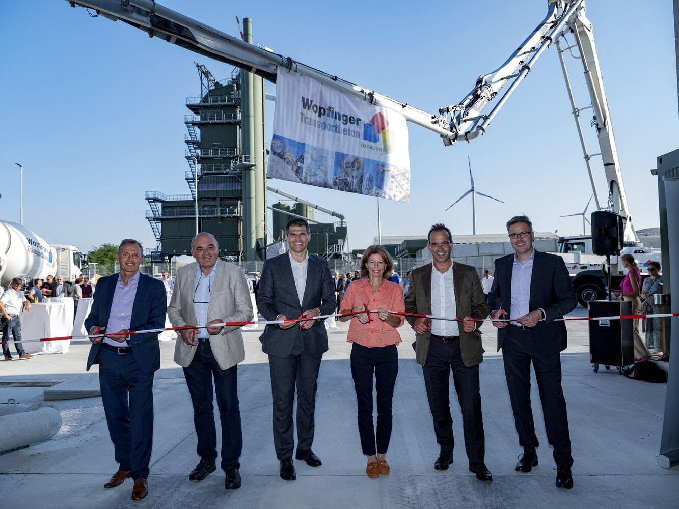 © Wopfinger Transportbeton
Neuerrichtung der modernen Mischanlage am Standort Seibersdorf (v.l.): Franz Denk (Technischer Geschäftsführer WTB) Vizebürgermeister Franz Püreschitz, Wolfgang Moser (Kaufmännischer Geschäftsführer WTB) Bezirkshauptfrau Verena Sonnleithner, Robert Schmid (Eigentümer) und Klaus Exner (WTB)
Fünf Herren und eine Dame stehen vor einem Transportbeton-Werk