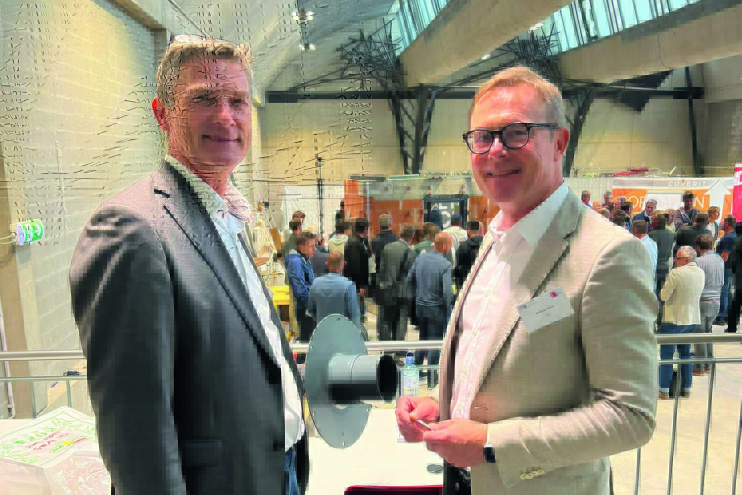 Fleck-Produktmanager Peter Nowack (l.) und IFB-Leiter Wolfgang Hubner beim IFB-Symposium 2022 in Salzburg. In der Hand hält Peter Nowack den Prototyp des Inspektionsöffnungsschachtes für Terrassen.