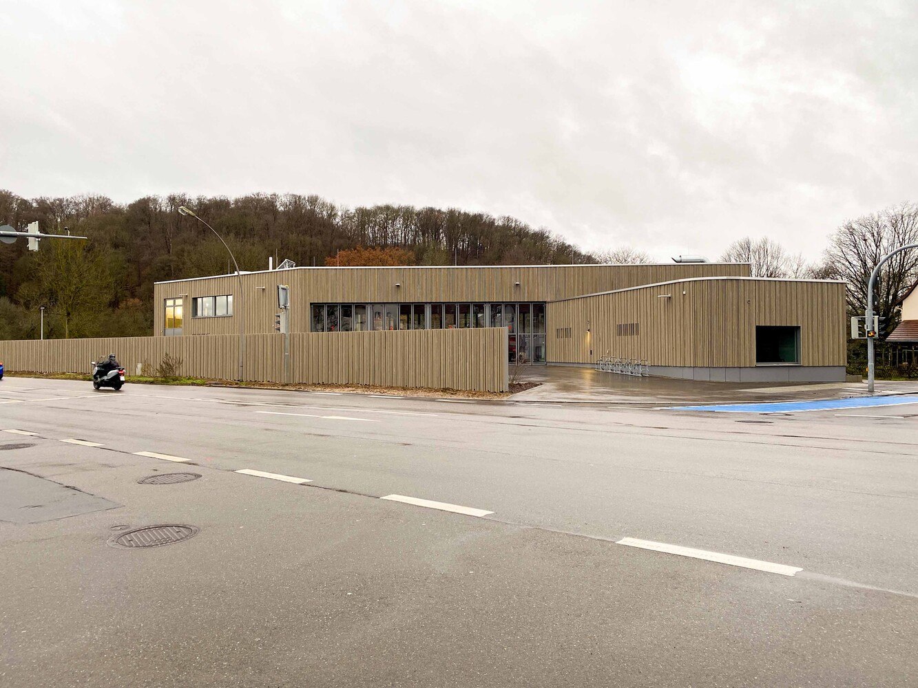 An die Halle grenzt an der Nordseite ein eingeschossiger Gebäudefinger für Lager, Werkstatt und Trockenraum an. Am anderen Ende der Halle, auf der Südseite, schließt ein zweigeschossiger Gebäudeteil an, dessen Attikahöhe die Höhe der Halle aufnimmt. 