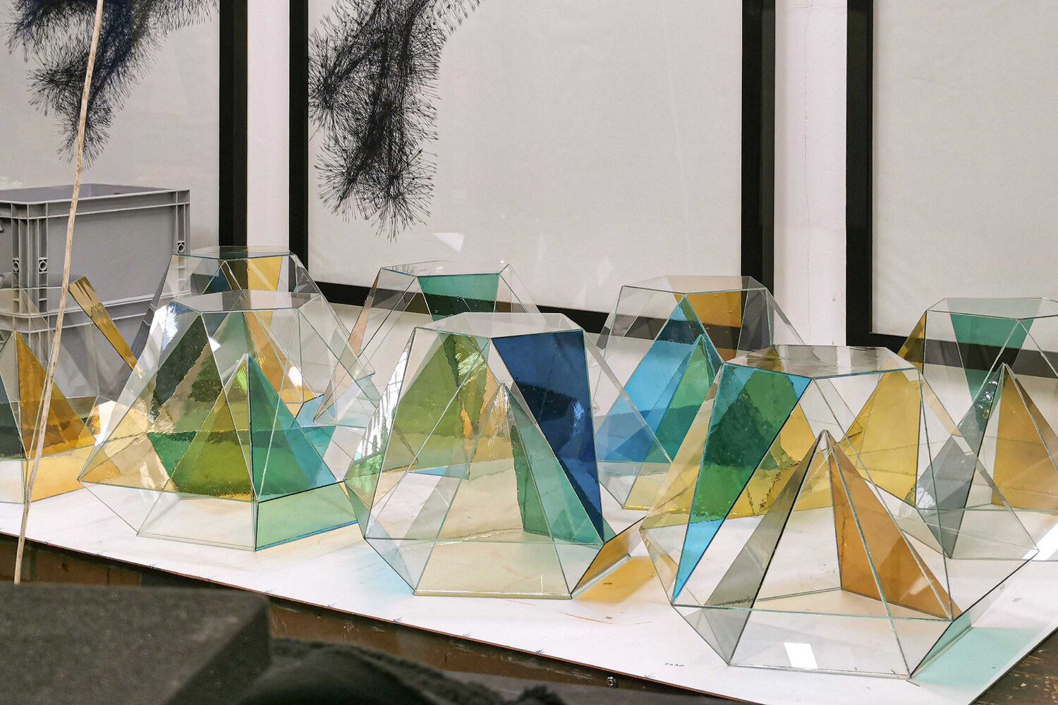 Die 12 geometrischen Glaskörper bestehen aus verschiedenfarbigen und farblosen Glasstücken und sind UV-verklebt.