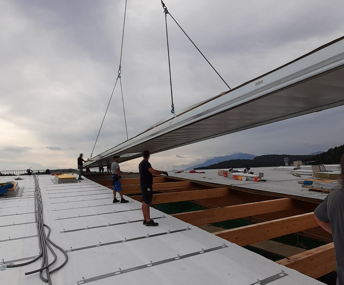 Die schnelle Verlegung der 25 Meter langen und 3,00 Meter breiten Domico-Dachelemente erfolgte über Pfetten von First zu Traufe in einem Hub.