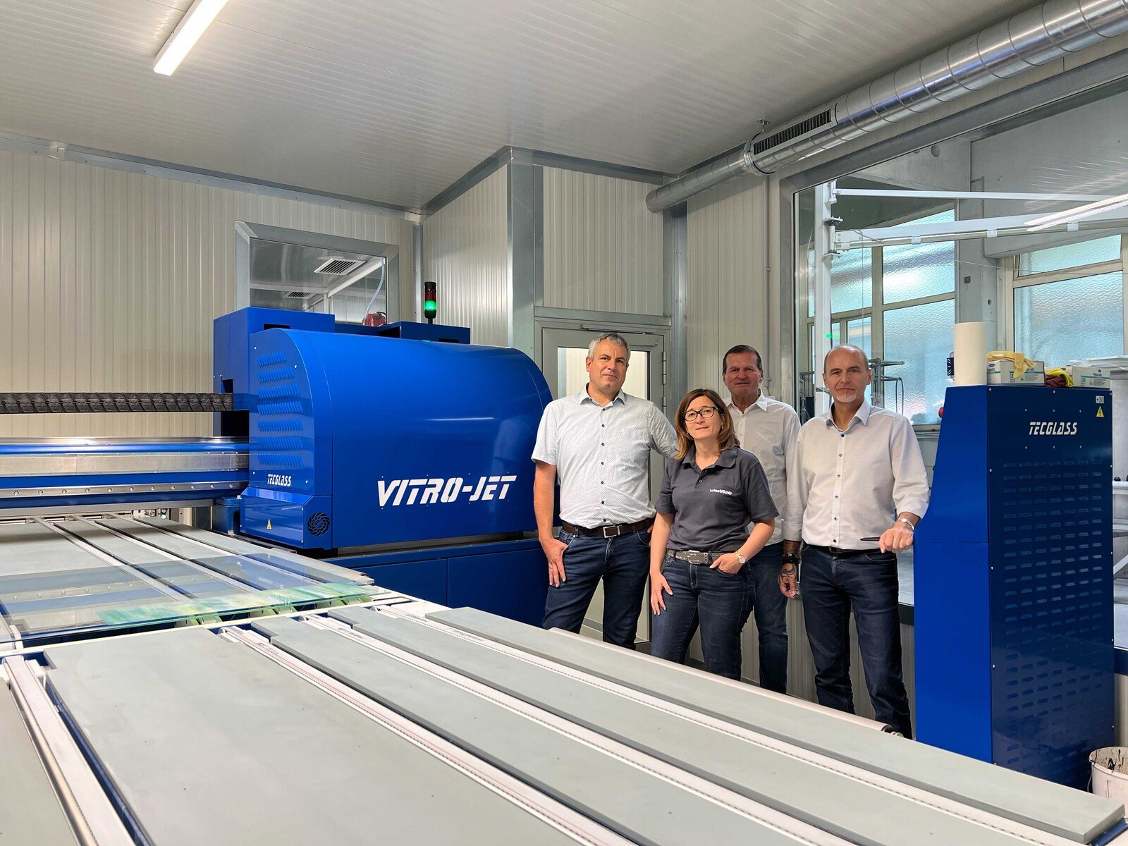 Gruppenfoto vor dem neuen Superdrucker (von links): Die beiden Geschäftsführer Gerald Wiesbauer-Pfleger und Michaela Wiesbauer, Tecglass-Exklusivvertreter Harald Kraus von  K & K ProVitrum und der Leiter der Druckabteilung bei Glas Wiesbauer Karl Klug. 