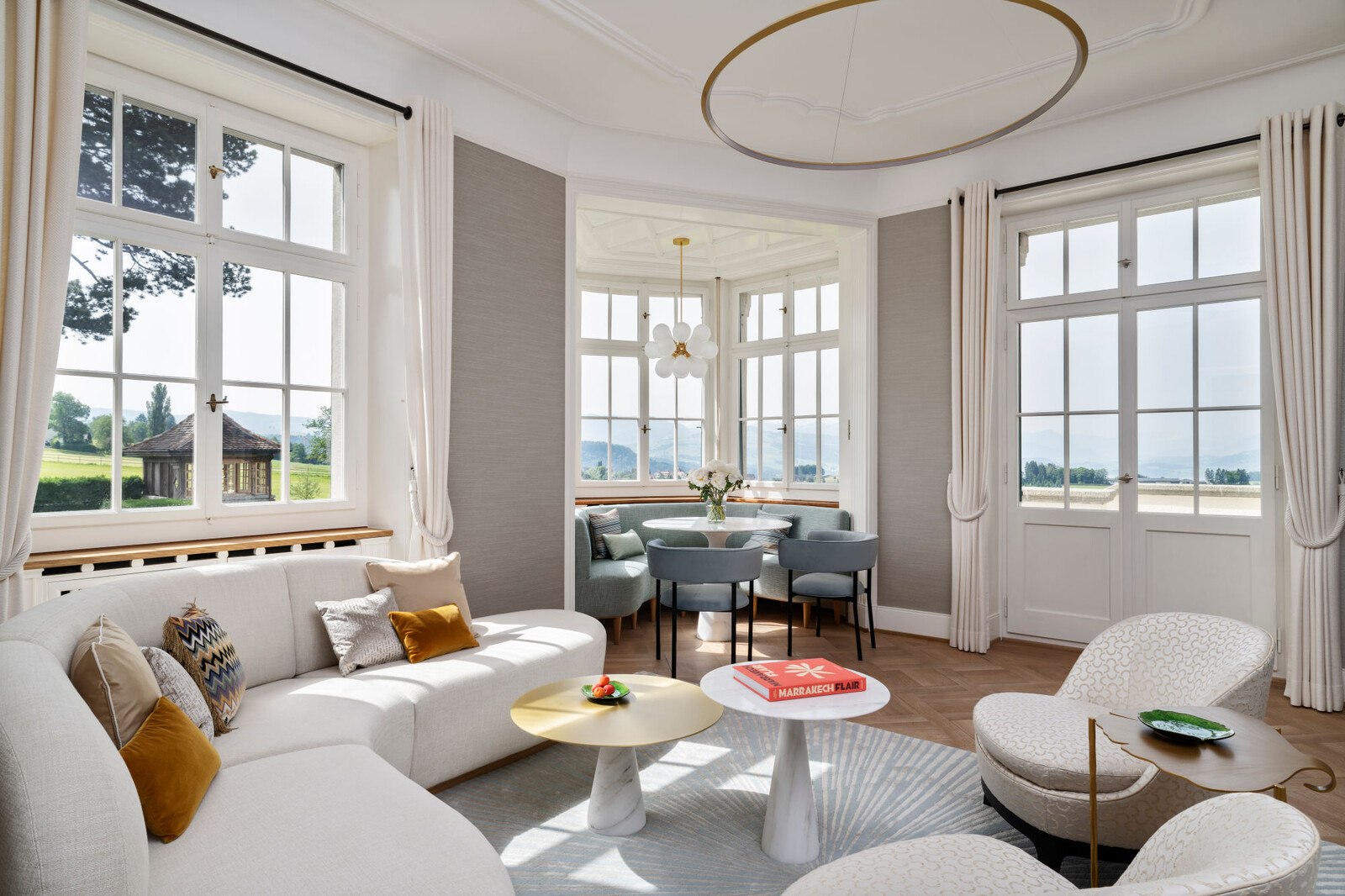Helles, großes Wohnzimmer mit vielen Fenstern.