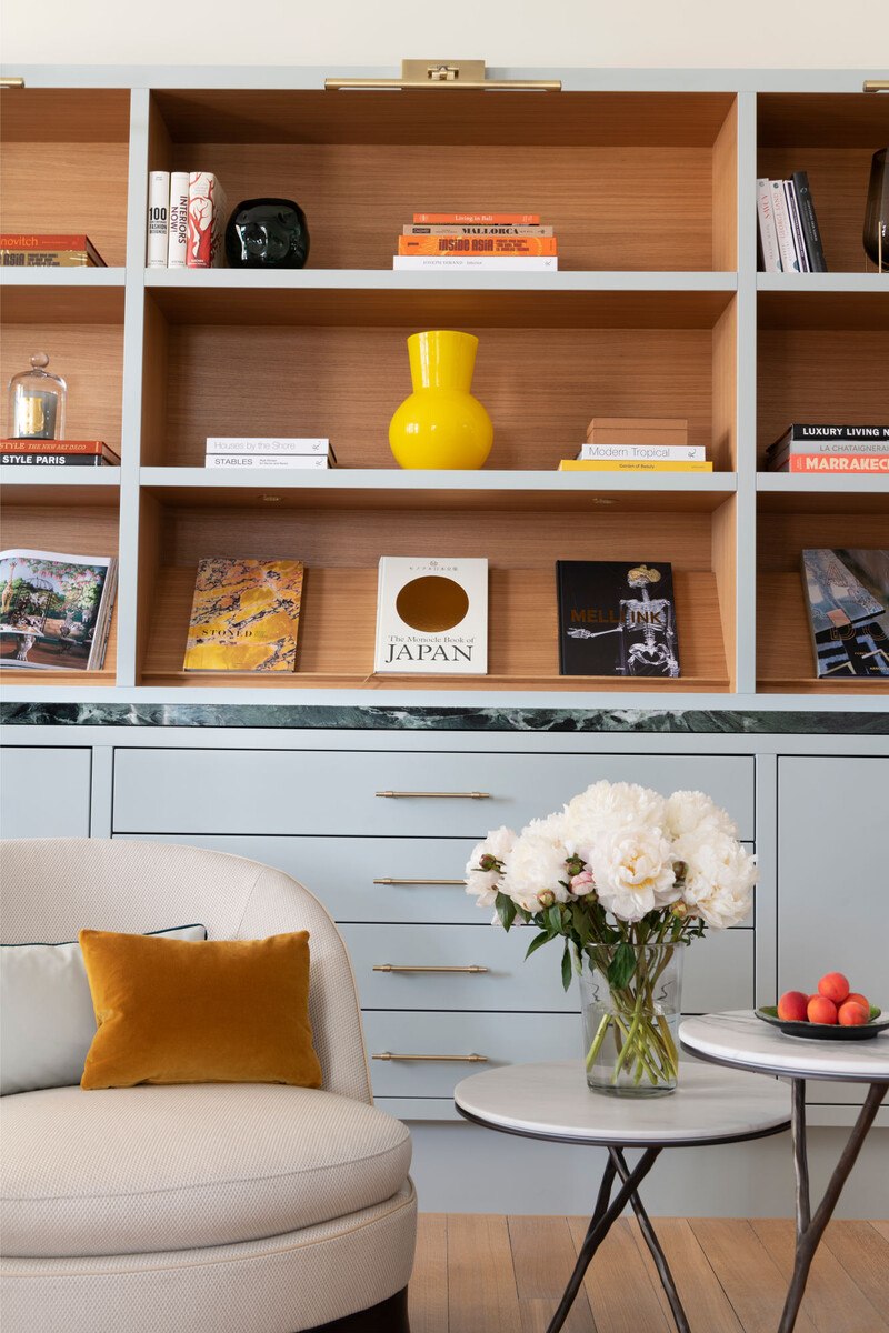 Wohnzimmer mit blauen Einbauschrank und viel Dekoration.