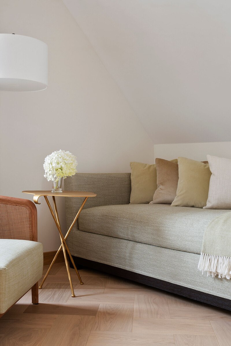 Graue Couch mit Pölstern und Beistelltisch.