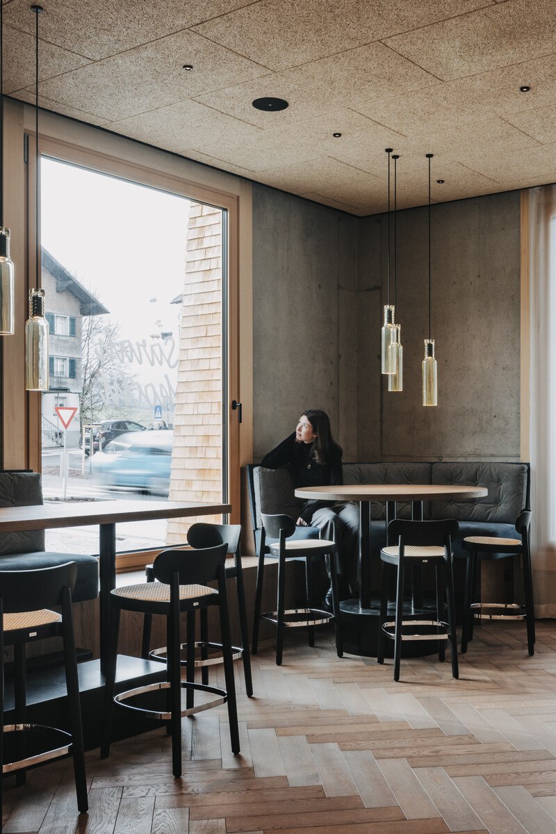 Eine Frau sitzt am Fenster in einem Restaurant.