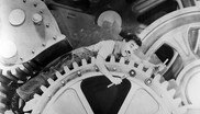 Charlie Chaplin in Modern Times zwischen Zahnrädern